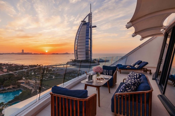 چشمانداز زیبا از برج العرب در غروب آفتاب از بالکن هتلی لوکس، یکی از جاهای دیدنی دبی که تجربهای آرامشبخش و منحصربهفرد را ارائه میدهد.
