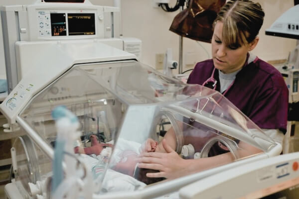 مهاجرت پرستاران - پرستار در حال رسیدگی به نوزاد