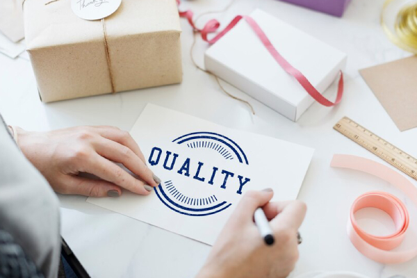 تصویری از یک کارت با کلمه کیفیت، نمادی از اهمیت ارائه محصولات و خدمات با استانداردهای جهانی در تجارت بینالمللی.