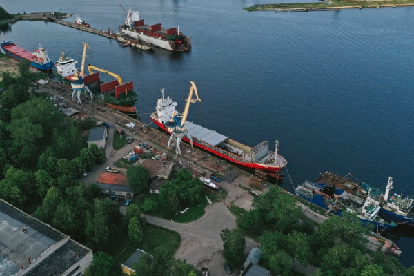 توسعه همکاریهای صادرات و واردات: نمای هوایی از بندر تجاری با کشتیهای باربری و کانتینرها در حال بارگیری و تخلیه