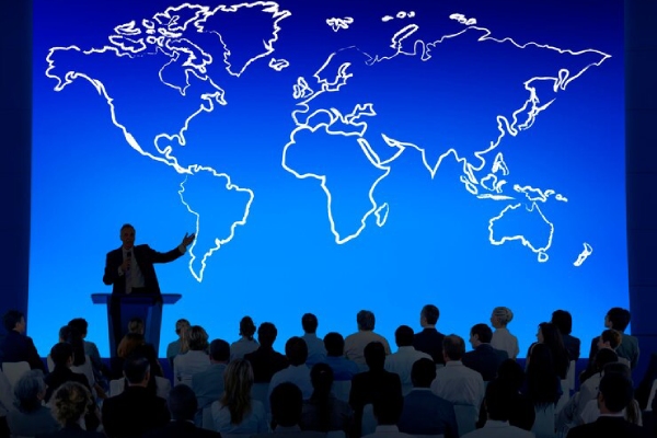 تصویری از یک کنفرانس بینالمللی با پسزمینه نقشه جهان که نمایانگر اهمیت حضور در رویدادهای بینالمللی برای گسترش روابط تجاری است.