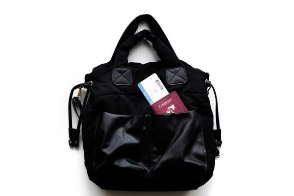 کیفی با پاسپورت و بلیت - اهمیت حفظ امنیت مدارک مهم در برنامهریزی سفر خارجی برای جلوگیری از مشکلات احتمالی