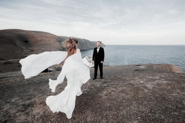 عروس و دامادی که در طبیعت زیبای یونان عکس میگیرند، نماد اقامت یونان از طریق ازدواج و شروع یک زندگی جدید.