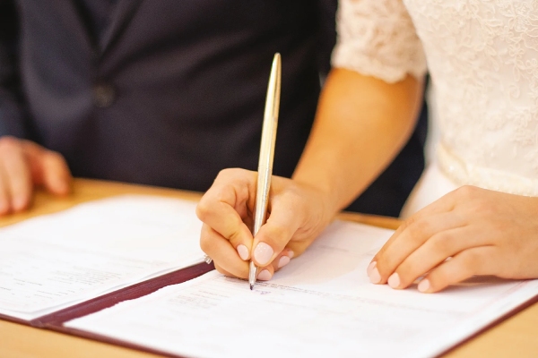 یک زوج در حال امضای اسناد رسمی برای ثبت ازدواج ایرانی در کانادا.