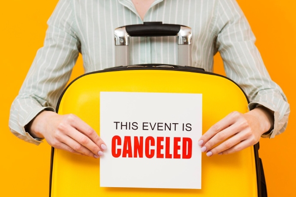 ریجکتی ویزای انگلیس - تصویر یک چمدان زرد با تابلویی که نشاندهنده لغو یا ریجکت شدن یک رویداد است، نمادین از رد شدن درخواست ویزا.